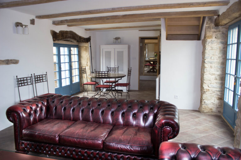 Living room with leather Chesterfield sofas, exposed beams and stone walls