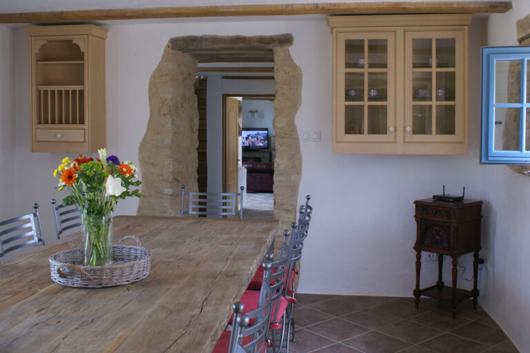 The dining room looking through a stone doorway into the living room