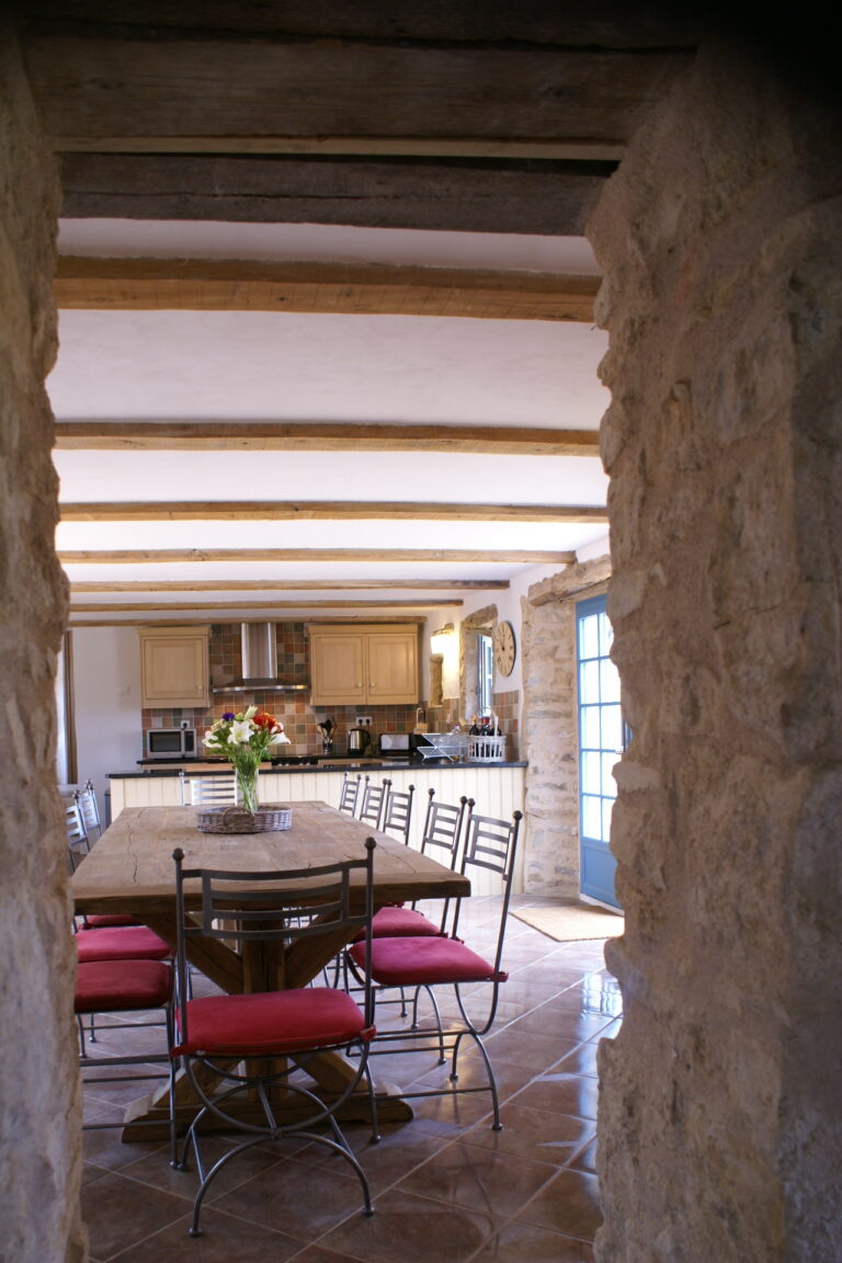 The dining table seen through an original stone doorway opening in the farmhouse wall