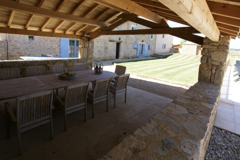 The covered barn beside the pool, with a long table and chairs for twelve looking out over the lawn