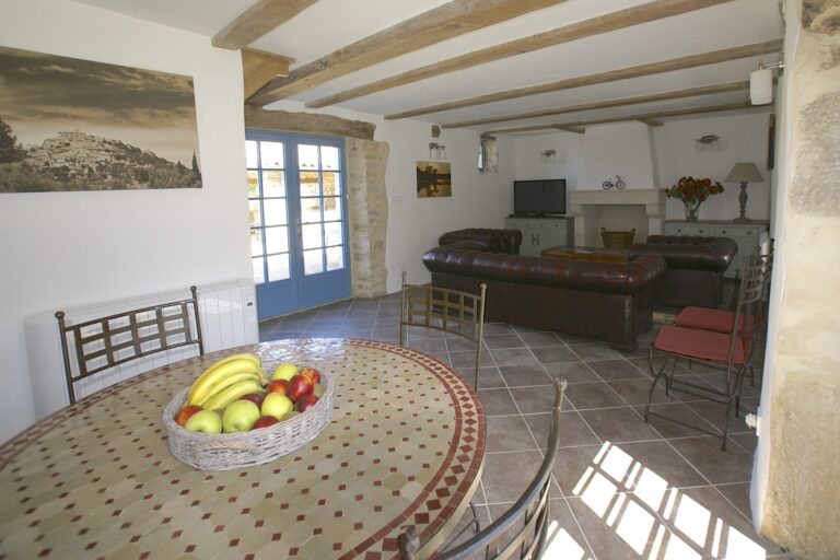 The living room, with leather Chesterfields, a beamed ceiling and a round mosaic table