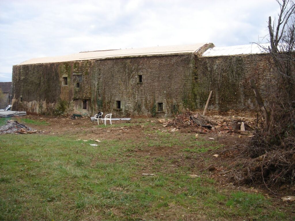 The long stone range before restoration, with new roof decking going on